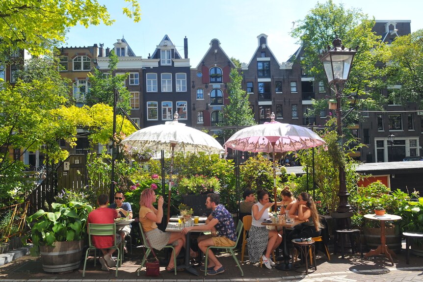 People sit at a cafe in Amsterdam