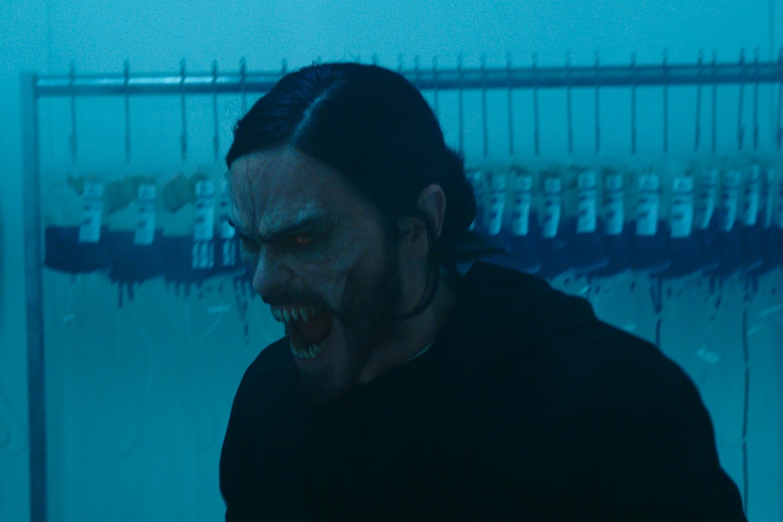 A long-haired, middle-aged man turns into a monster, with sharp vampire teeth