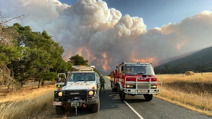 A fire truck and 4WD in front of a raging bushfire in the Nariel Valley in Victoria.