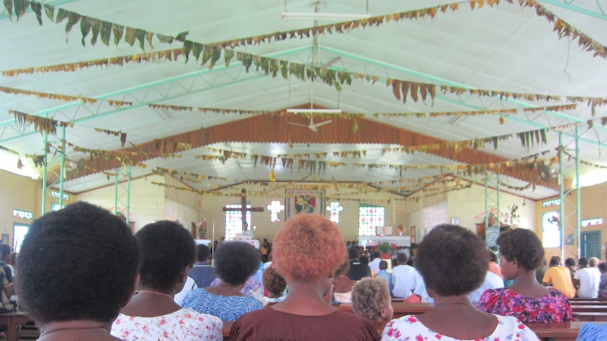 Papua New Guineans sitting in a church for a town meeting
