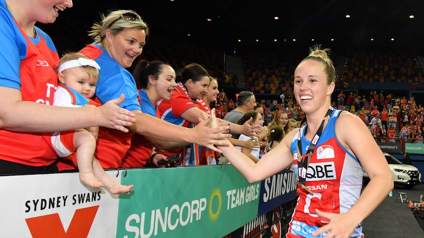 NSW Swifts player Paige Hadley high-fives fans after the Super Netball grand final.