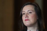Kelly O'Dwyer looks stern at a press conference. She's wearing a black blazer and beige top.