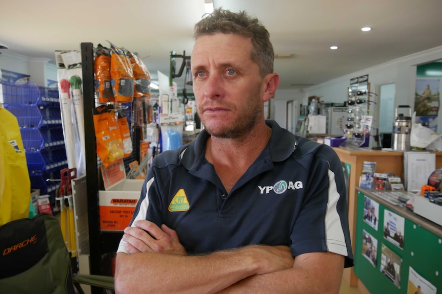 A man standing in an agricultural supplies shop.