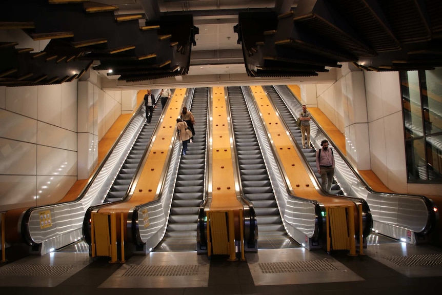 Only about four people ride big escalators going into train station