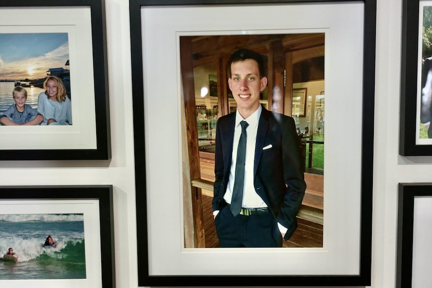 A framed photo of a teenager on a wall.