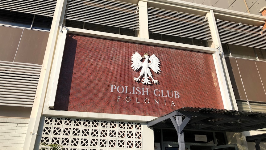 A polish logo on a building wall with "Polonia" written below it.