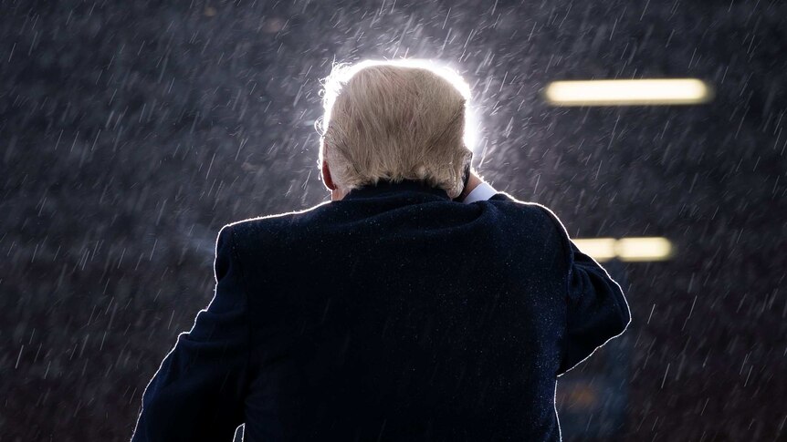 President Donald Trump speaks during a campaign rally in the rain