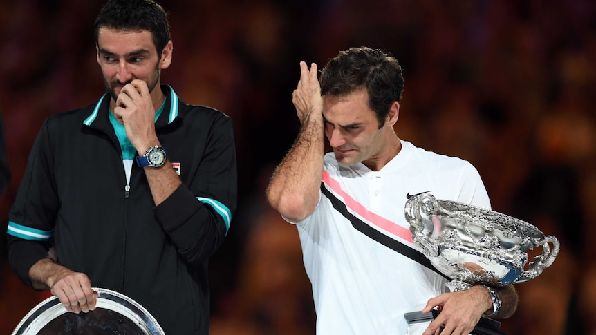 An emotional Roger Federer stands next to Marin Cilic after the Australian Open final
