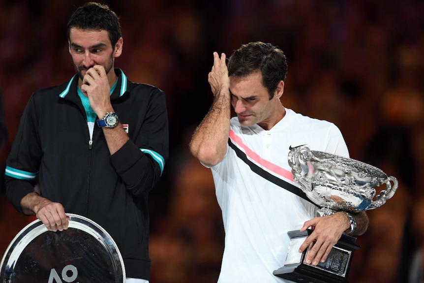 An emotional Roger Federer stands next to Marin Cilic after the Australian Open final