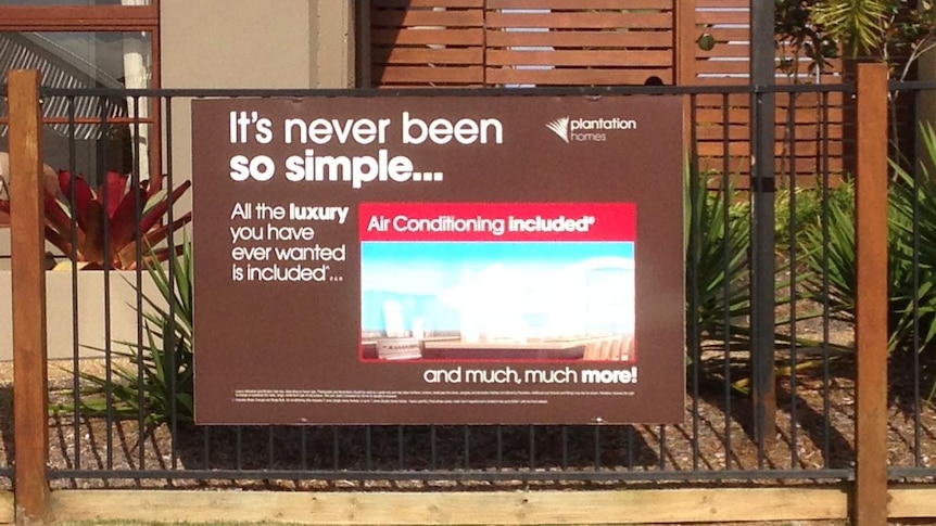 A real estate advertisement attached to a fence, promoting air conditioning.