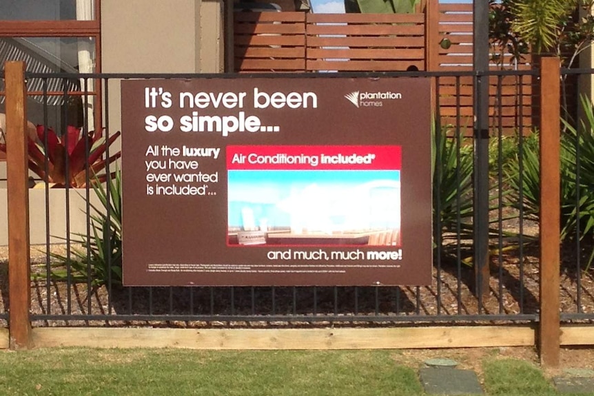 A real estate advertisement attached to a fence, promoting air conditioning.