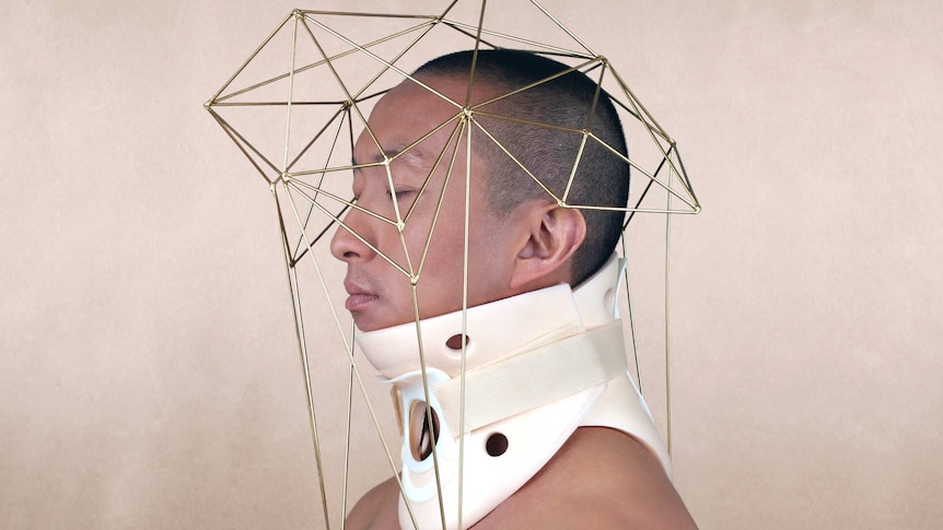 A piece of art showing a man with a neck brace and a geometric wire sculpture over his head