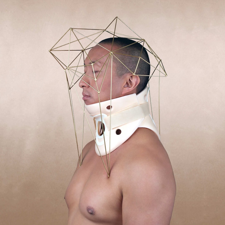 A piece of art showing a man with a neck brace and a geometric wire sculpture over his head
