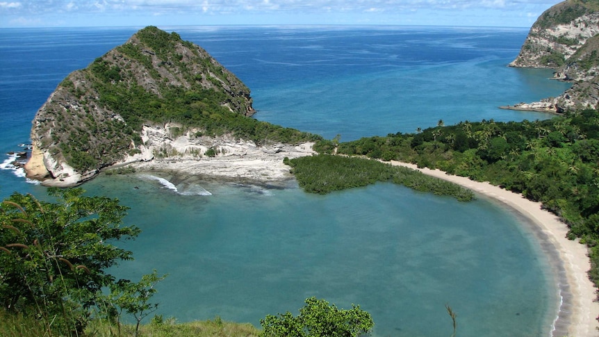 A photograph of a small island with many steep hills and cliffs