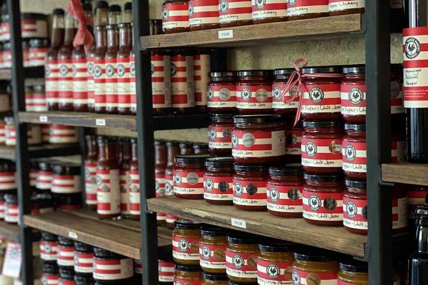 Jars of jams and preserves on shelves.