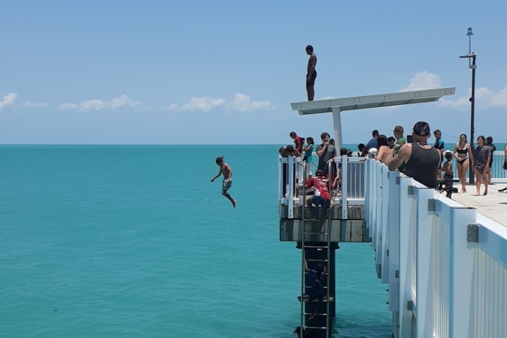 A person jumps of a jetty.