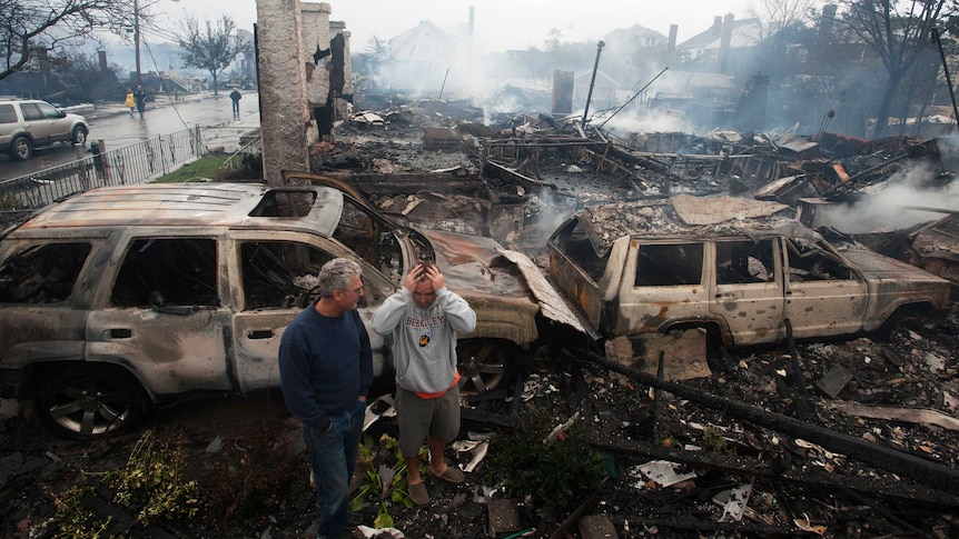 Residents look over the remains of burned homes in the Rockaways section of New York.