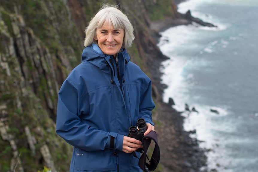 woman on cliff with water behind