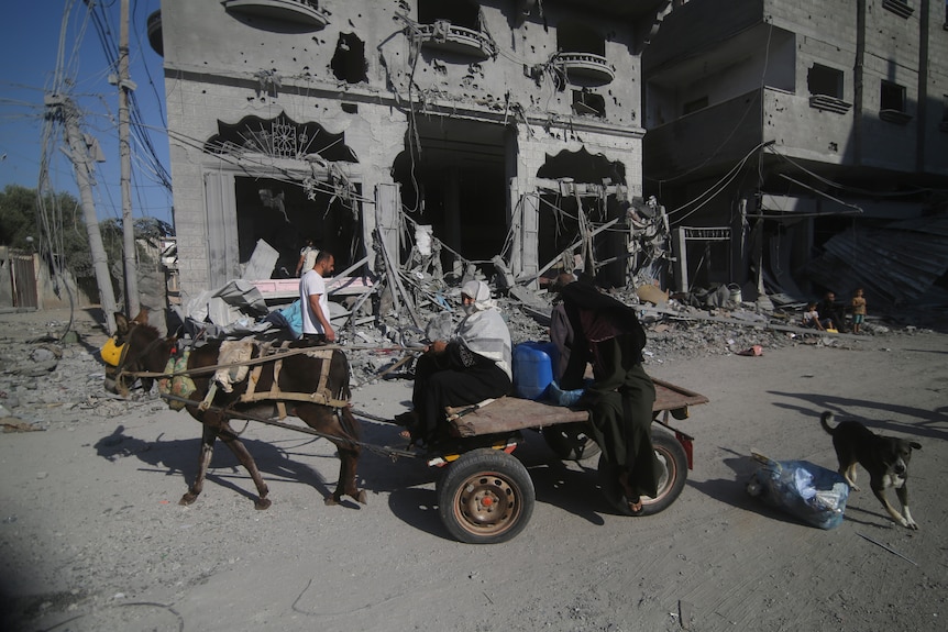 People leave their houses after air strikes in Gaza.