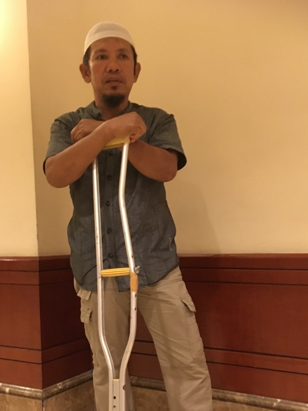 Man poses with crutches