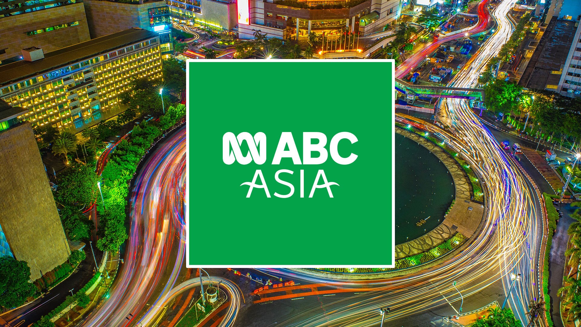  A bustling city at night with light trails from traffic and a logo reading "ABC Asia" overlayed.