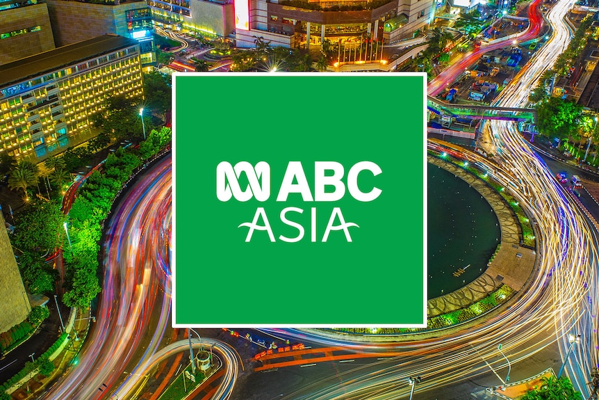  A bustling city at night with light trails from traffic and a logo reading "ABC Asia" overlayed.