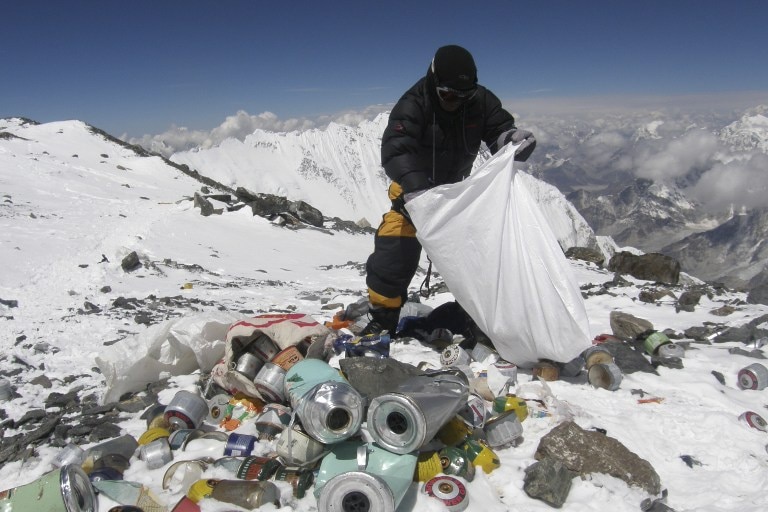 A Sherpa collects trash on Mount Everest. 