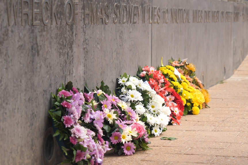 flower wreathes next to a memorial.