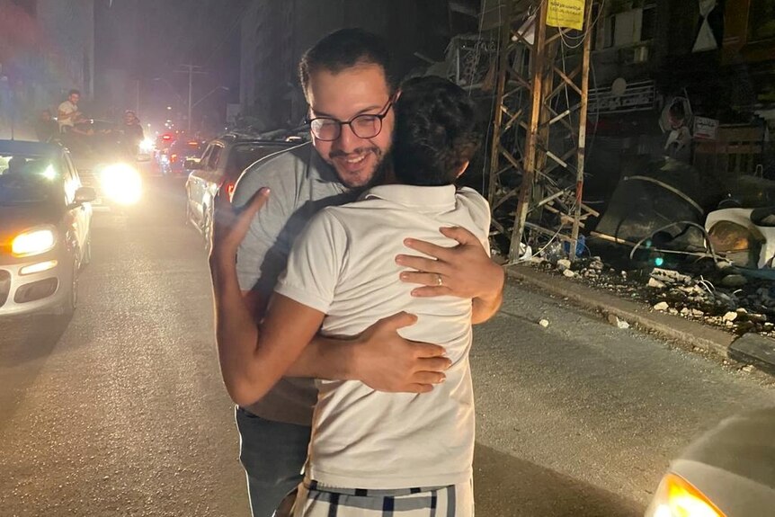Two men hug each other on the streets of Gaza.