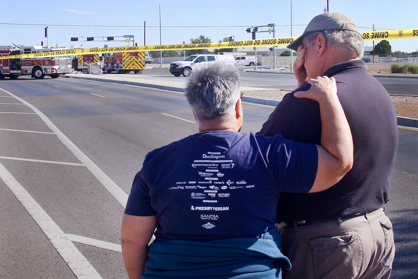 Пожилая женщина утешает пожилого мужчину в зоне экстренной помощи на открытом воздухе