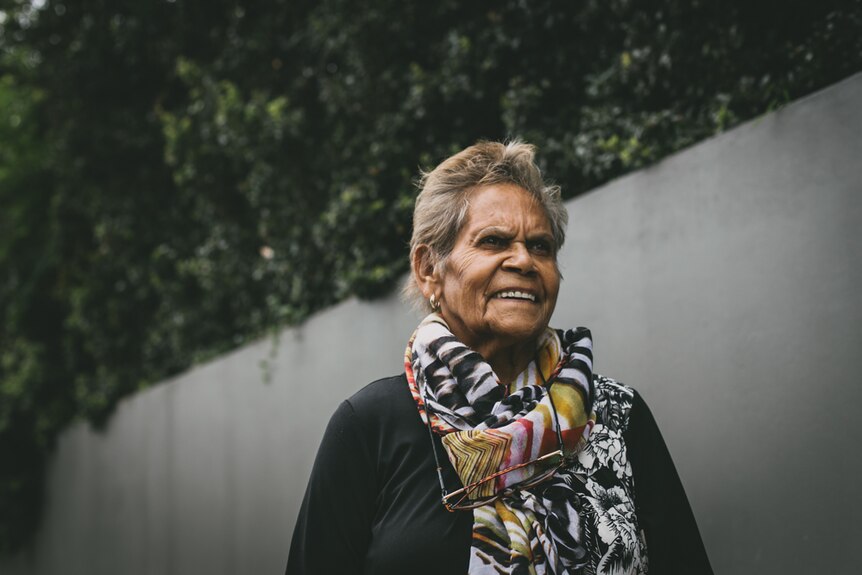 Portrait of Aboriginal elder Rev. Dorothy Gordon with a wooden fence behind her