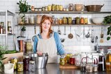 Alex Elliot Howery stands in her commercial kitchen behind a bench full of stocks, pickles and preserves that reduce food waste.