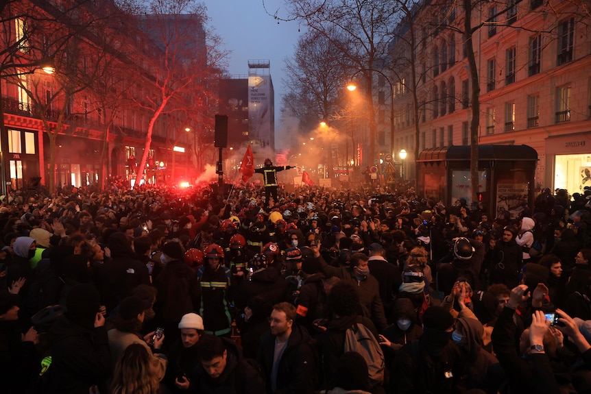 a large group of protesters march during a rally in Paris over pension reforms