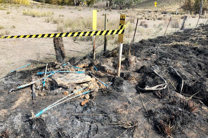 Wires protruding from a charred field