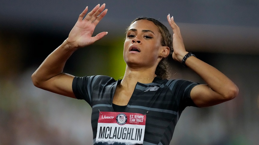 A US female athlete raises her hands towards her head as celebrates breaking a world record.