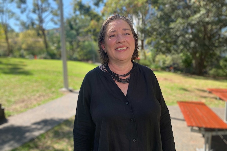 Job seeker Liesl Filippi standing in a park on a sunny day with trees behind.