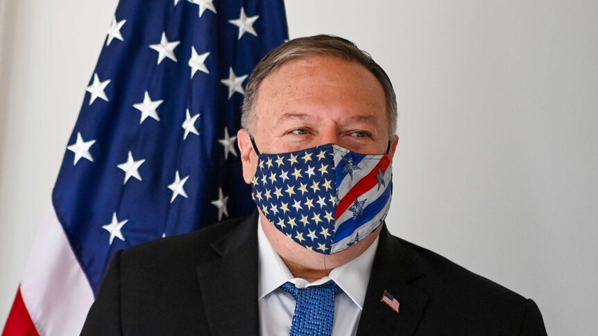 Mike Pompeo in a face mask with a US flag behind him
