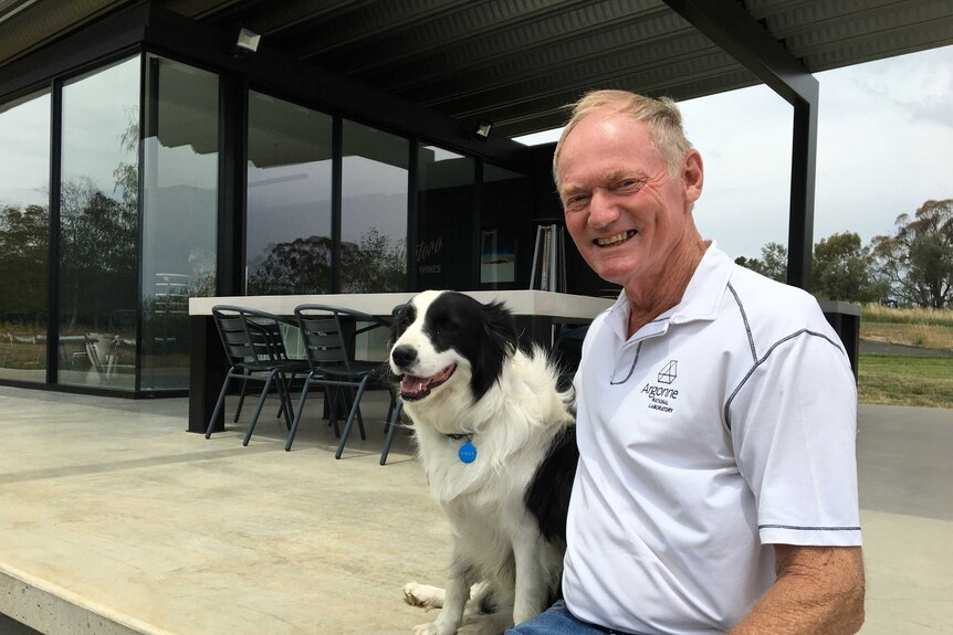 Winemaker Bob Derrick and his dog Bailey sitting outside the cellar door on his winery in Orange NSW