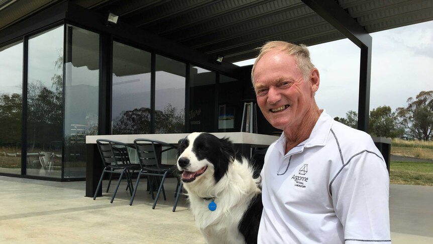 Winemaker Bob Derrick and his dog Bailey sitting outside the cellar door on his winery in Orange NSW