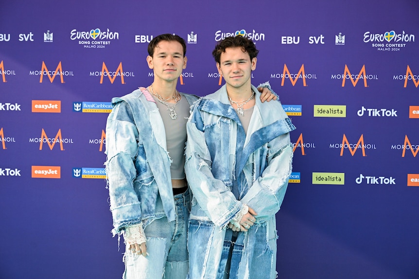 Marcus & Martinus wearing matching denim suits with grey shirts underneath 