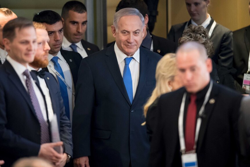 Israel's Prime Minister Benjamin Netanyahu standing in a crowd of people at the International Security Conference in Munich.