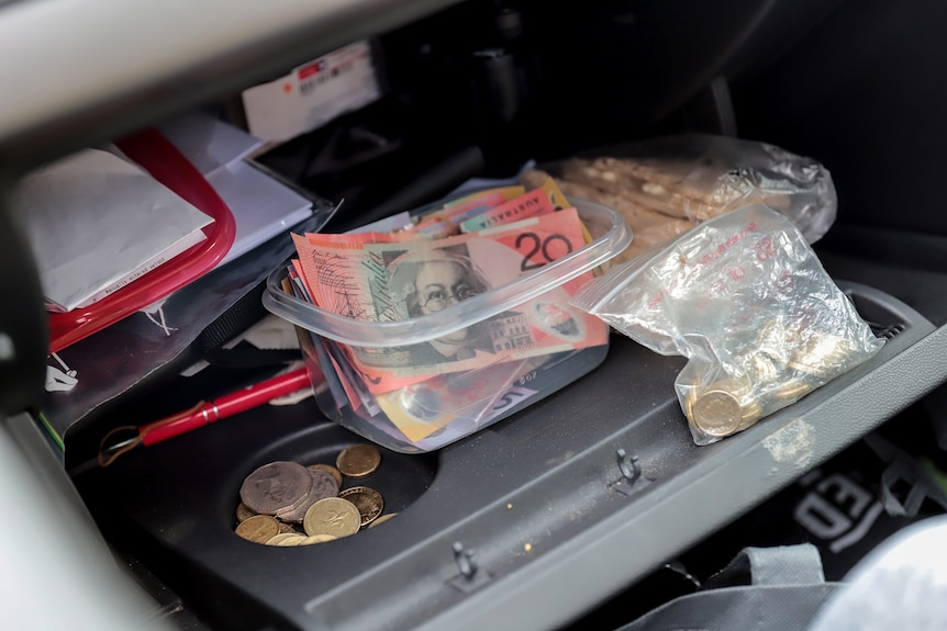 Cash in a container in a car glovebox 