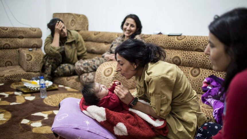 Mother, sister and baby play in a room