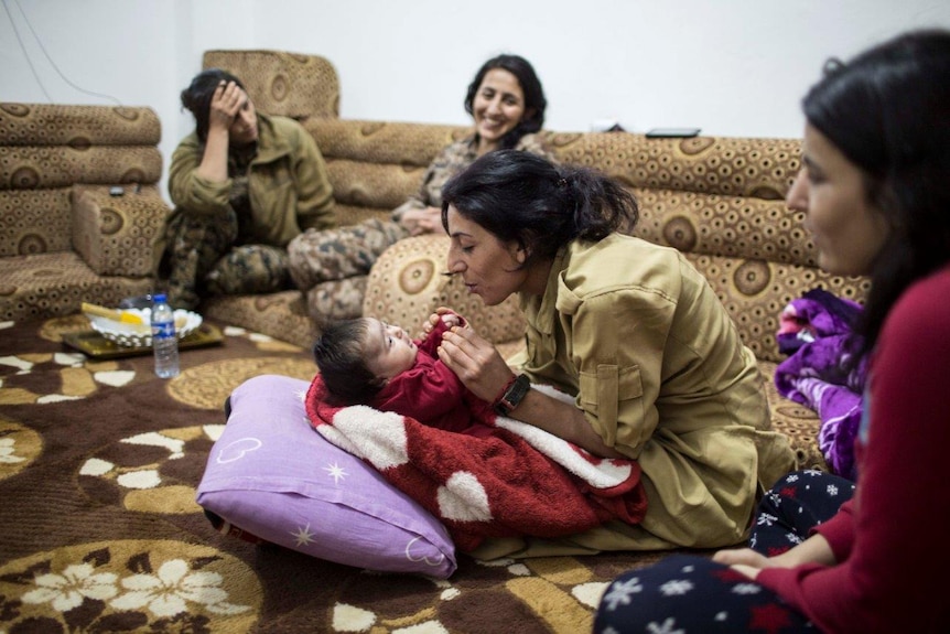 Mother, sister and baby play in a room