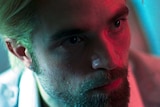 Still colour close-up image of Robert Pattinson's face looking to the right, off camera.