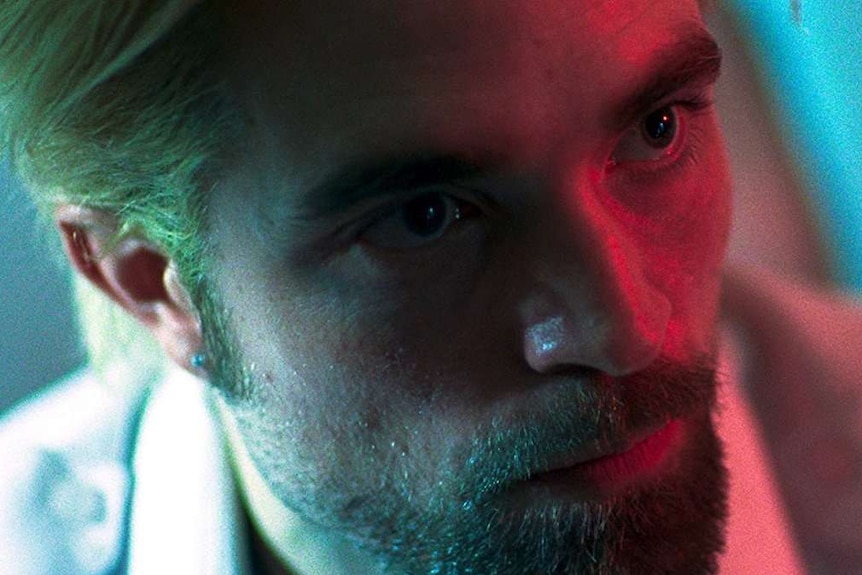 Still colour close-up image of Robert Pattinson's face looking to the right, off camera.