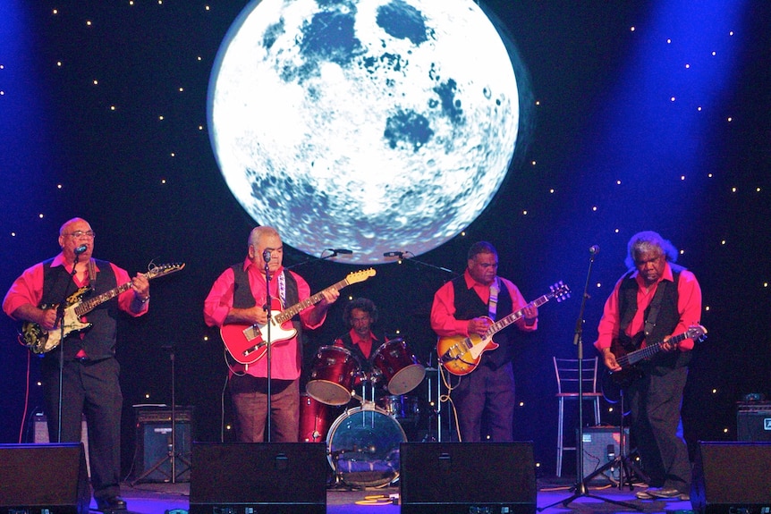 An image of the Mop & the dropout band playing with moon on screen in background
