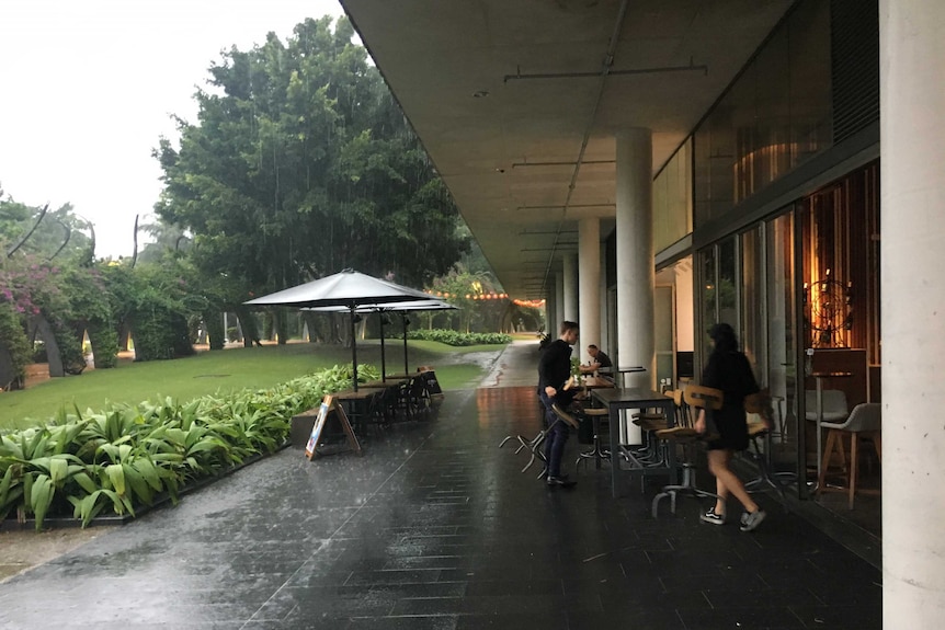 A business opens in heavy rain at Southbank in Brisbane