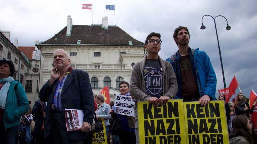 Protestors with signs gathered outside the office of the Austrian president, demonstrating against Norbert Hofer