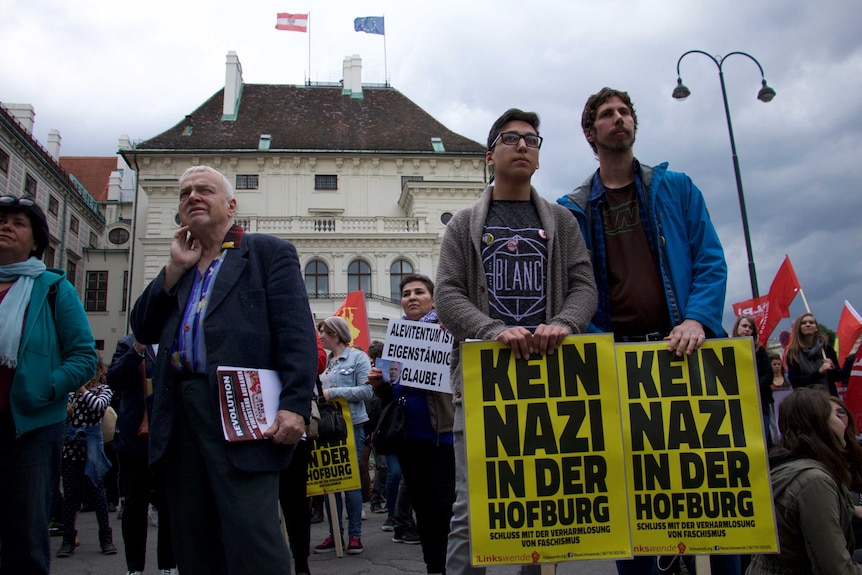 Protestors with signs gathered outside the office of the Austrian president, demonstrating against Norbert Hofer